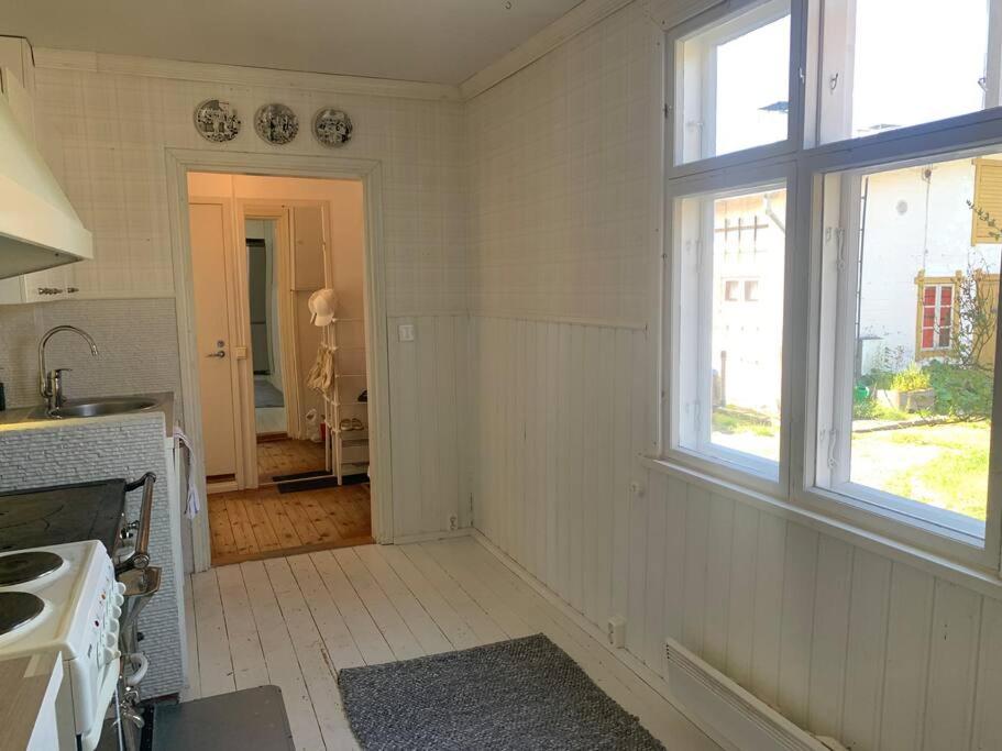 a white kitchen with a sink and a window at In the heart of Old Rauma in Rauma