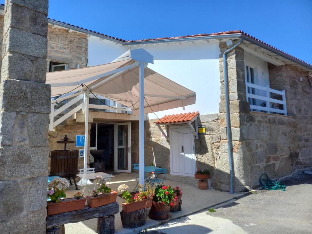 a white awning on the front of a house at Pensión O Corazón da Ribeira Sacra in La Teijeira