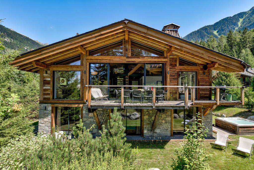 Cette maison en rondins dispose d'une grande terrasse avec des portes en verre. dans l'établissement Chalet Black Stone, à Chamonix-Mont-Blanc