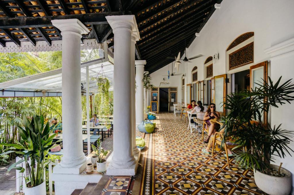 a restaurant with columns and people sitting at tables at Prana Home in Colombo