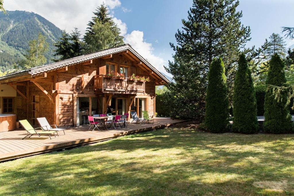 une cabane en rondins avec une terrasse et des chaises. dans l'établissement Chalet Les Favrands, à Chamonix-Mont-Blanc