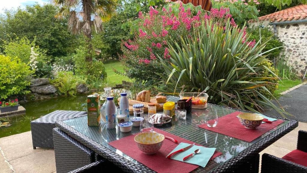 uma mesa com comida e bebidas num jardim em Au bon endroit em Sevremont