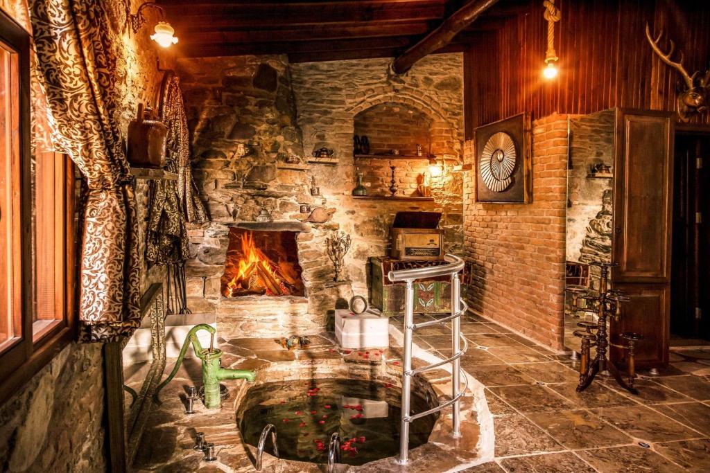 a stone room with a fireplace and a fire pit at Stonehouse in Selçuk