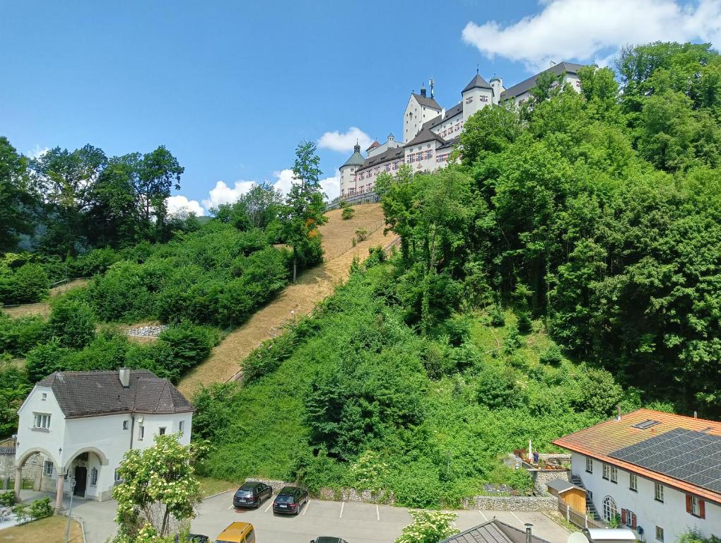 a building on the side of a hill with cars at Appartment Schloss-Zeit in Aschau im Chiemgau