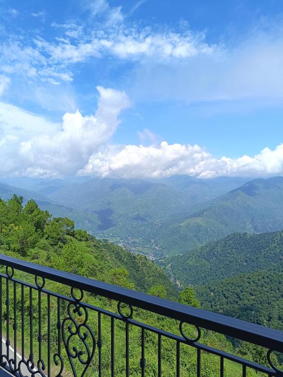 a view of a mountain valley from a balcony at Windmill Inn in Solan