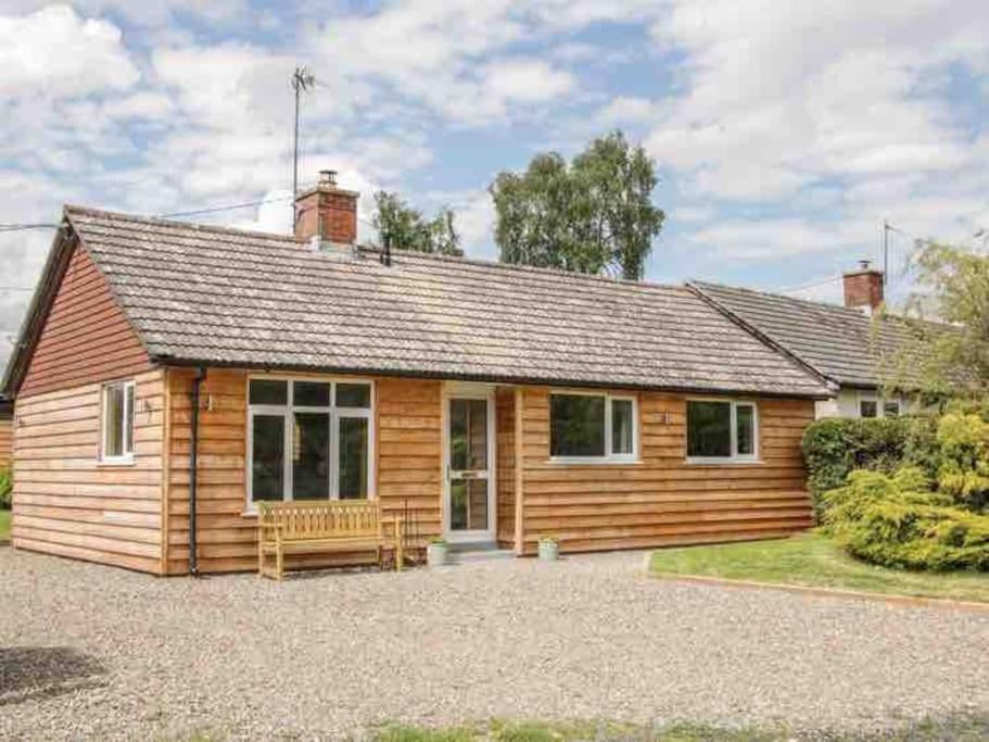 a log cabin with a bench in front of it at Edge View Cottage in Church Stretton