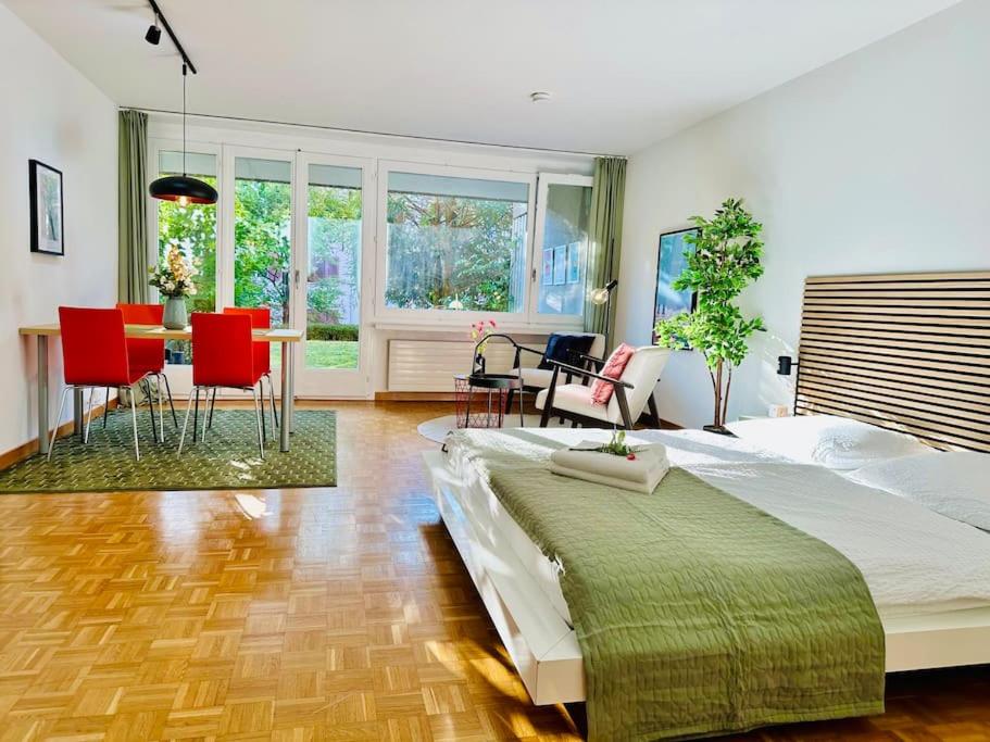 ein Schlafzimmer mit einem großen Bett und einem Tisch und Stühlen in der Unterkunft New, central studio with garden terrace and much privacy in Zürich