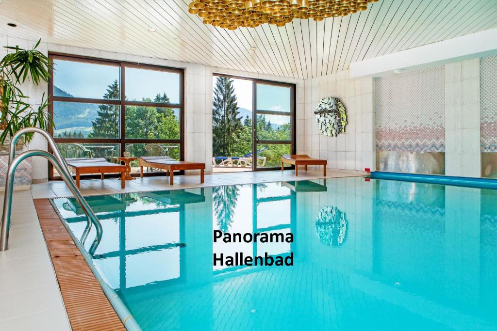 a swimming pool in a hotel room with a large window at Appartementhaus Dachsteinblick in Bad Goisern