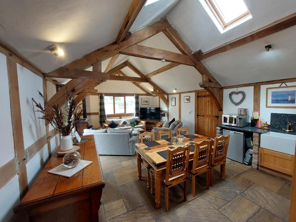 a kitchen and living room with a table and chairs at Barnacre Green Cottage with Hot Tub and Private Pool in Moreton