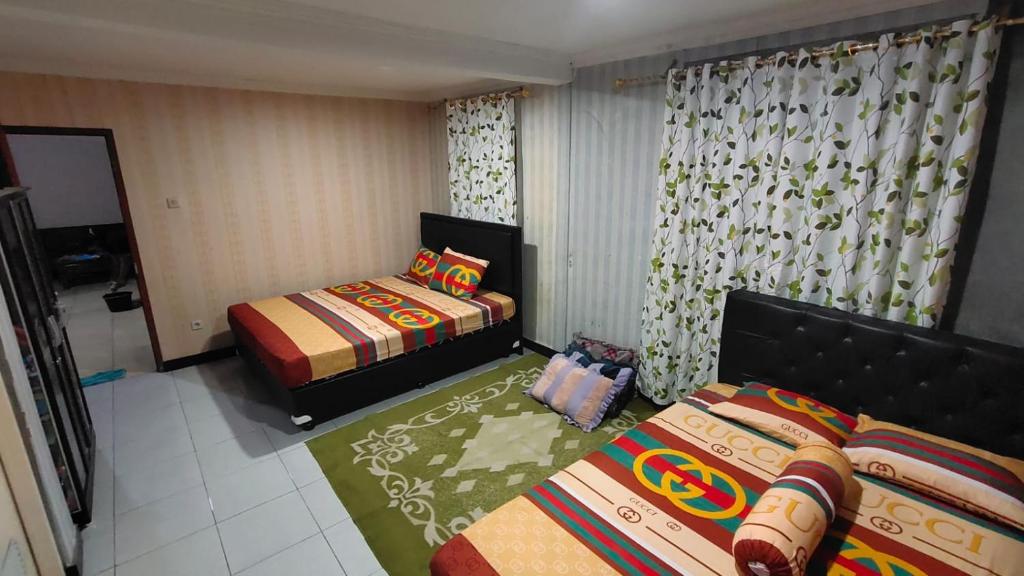 a small bedroom with two beds and a window at Anugerah Homestay Playen in Siyonokulon