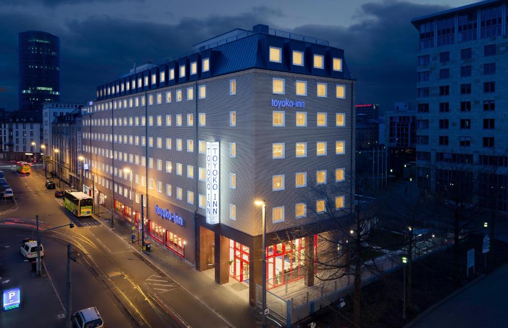 a lit up building on a city street at night at Toyoko Inn Frankfurt am Main Hauptbahnhof in Frankfurt/Main