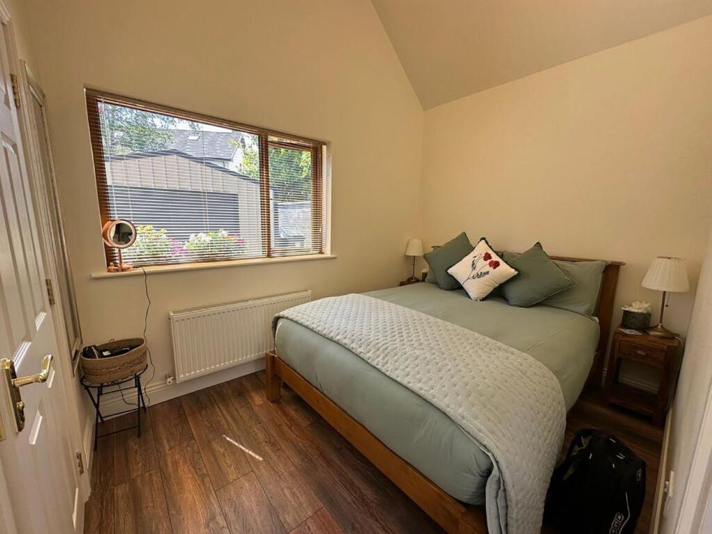 Habitación pequeña con cama y ventana en Oranhill Lodge Guesthouse en Oranmore