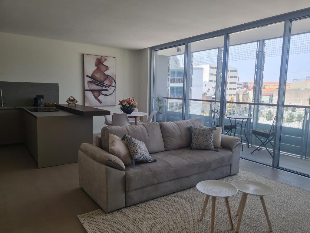 Luxury apartment Lisbon في لشبونة: غرفة معيشة مع أريكة ونافذة كبيرة