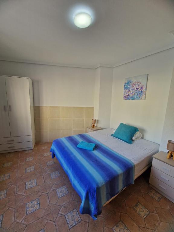 a bedroom with a large bed with blue sheets at Casa Alboraya Valencia in Alboraya