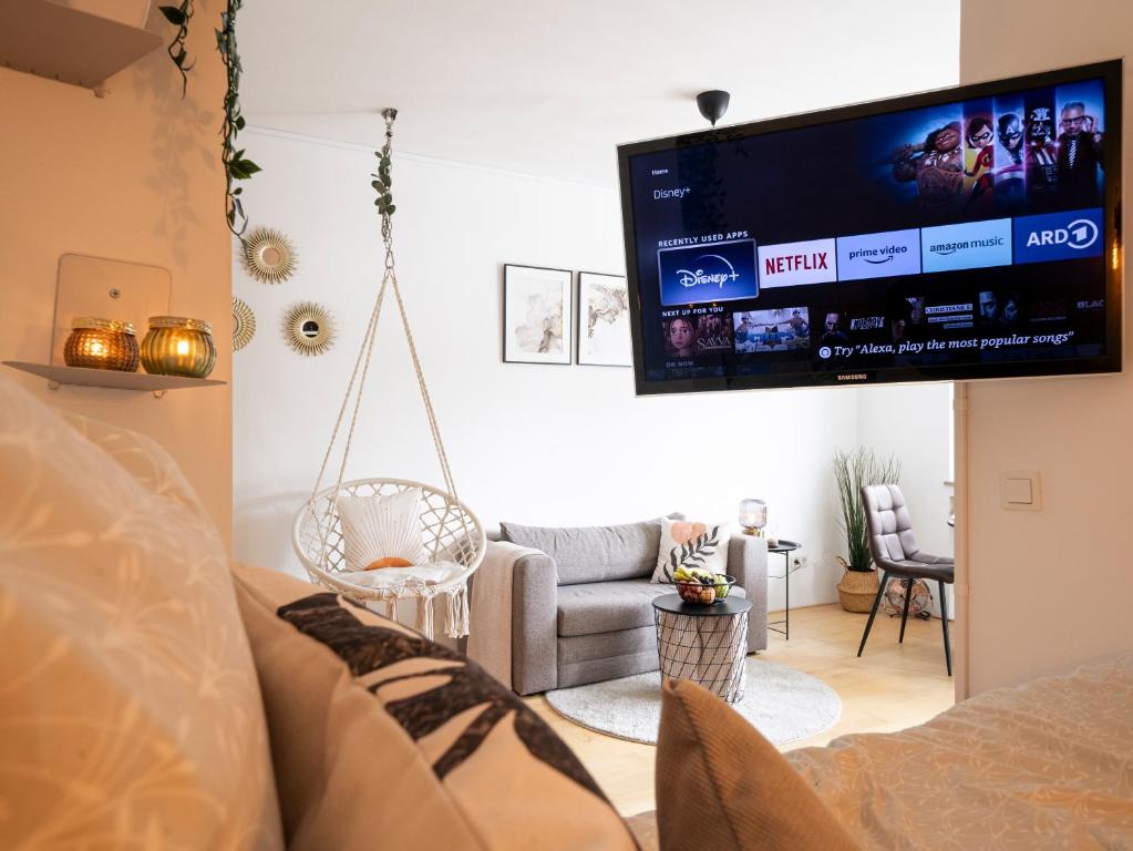 a living room with a couch and a flat screen tv at Zentrale & gemütliche Wohnung mit Sonnenbalkon in Essen