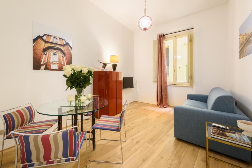 Una sala de estar con una mesa de cristal y un sofá azul. en Lucky House by Mmega, en Florencia