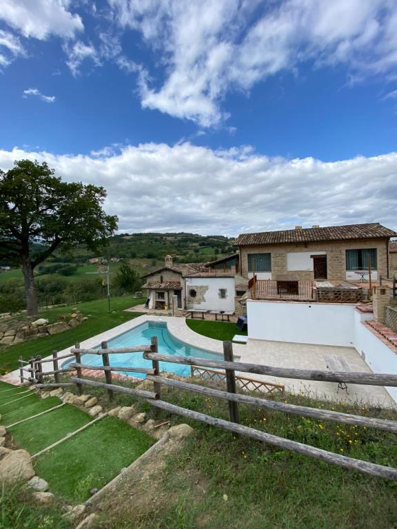 a house with a swimming pool and a fence at Villa Lucia - Homelike Villas in Camporotondo di Fiastrone