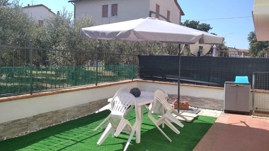 a table and two chairs under an umbrella on a patio at Appartamento Martina in Rapolano Terme