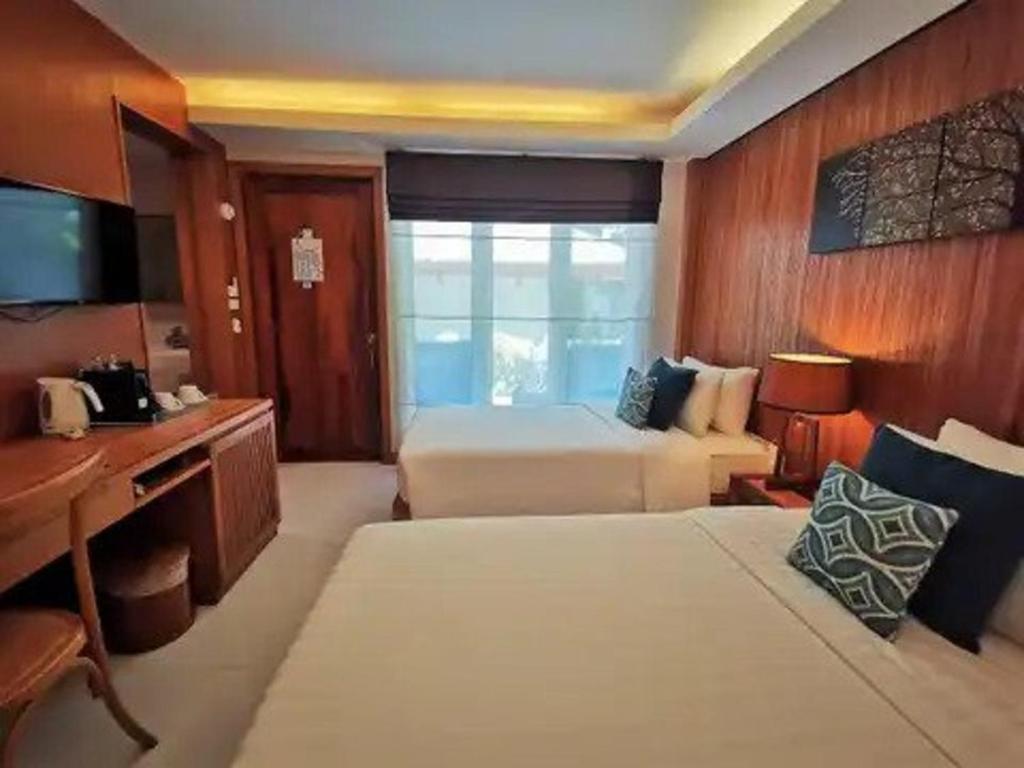a hotel room with two beds and a desk and a desk at Synergy Samui in Chaweng