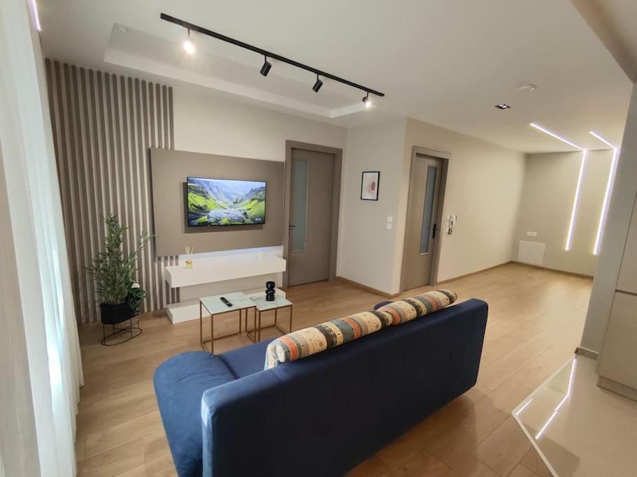 a living room with a blue couch and a tv at Luxury Apartments Deskati A1 