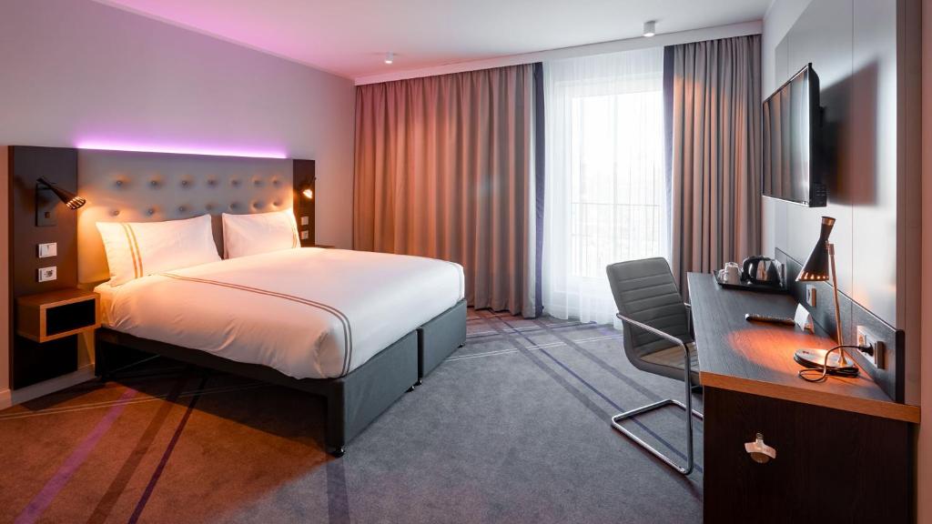 a hotel room with a bed and a desk and a television at Premier Inn Nürnberg City Opernhaus in Nuremberg