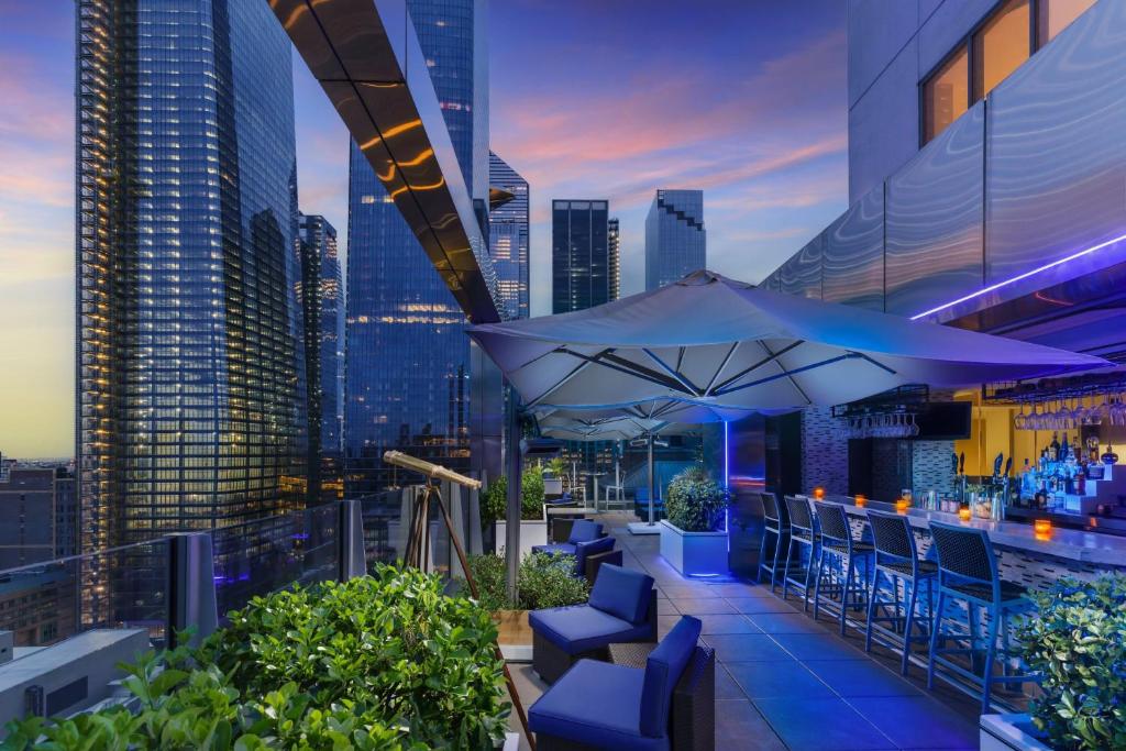 a rooftop bar with blue chairs and a city skyline at Fairfield Inn & Suites by Marriott New York Midtown Manhattan/Penn Station in New York