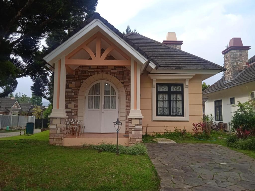 une petite maison avec une porte blanche dans l'établissement Villa Kota Bunga little indian happy, à Cikundul