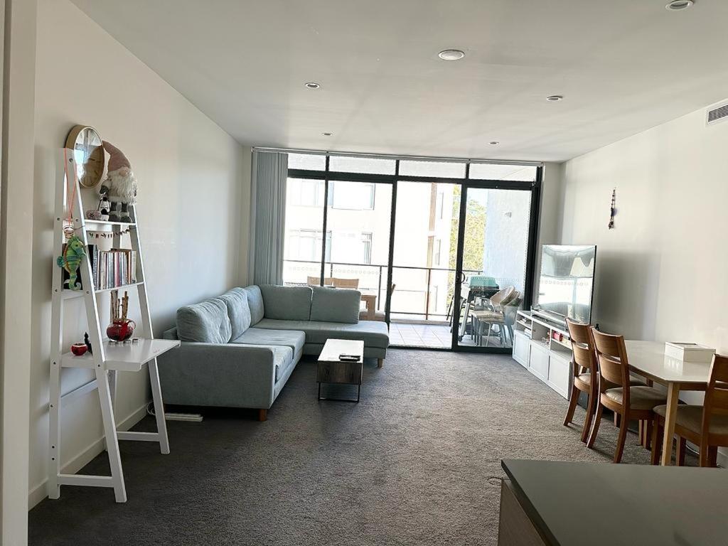 a living room with a couch and a table at Private ensuite room in a beautiful nature area in Sydney