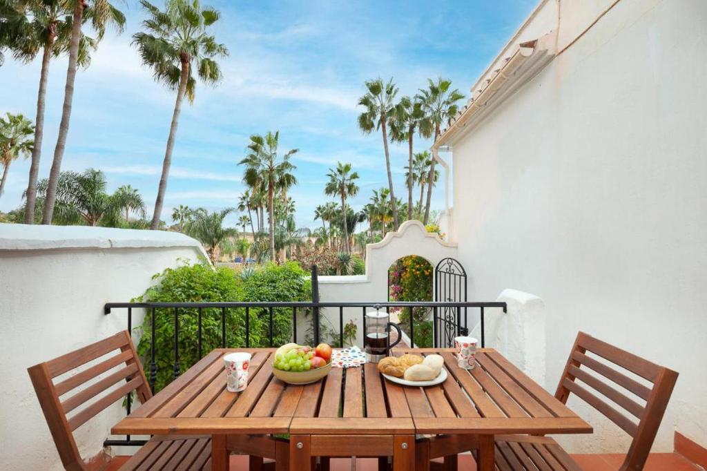 una mesa de madera con cuencos de fruta en el balcón en Casablanca 46 Oasis Properties, en Nerja