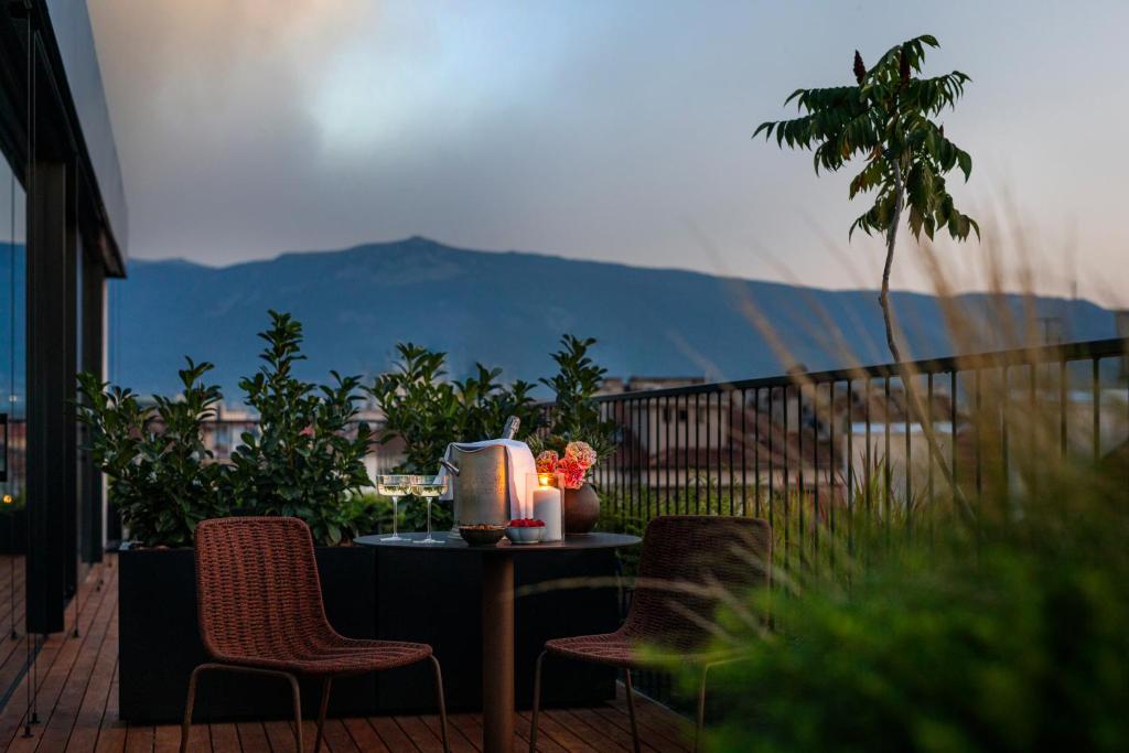 a table and chairs on a balcony with a view at Juno Hotel Sofia, a Member of Design Hotels in Sofia