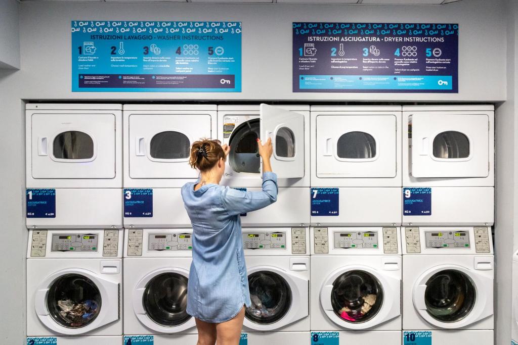 a woman is looking at a washing machine at Plus Florence in Florence
