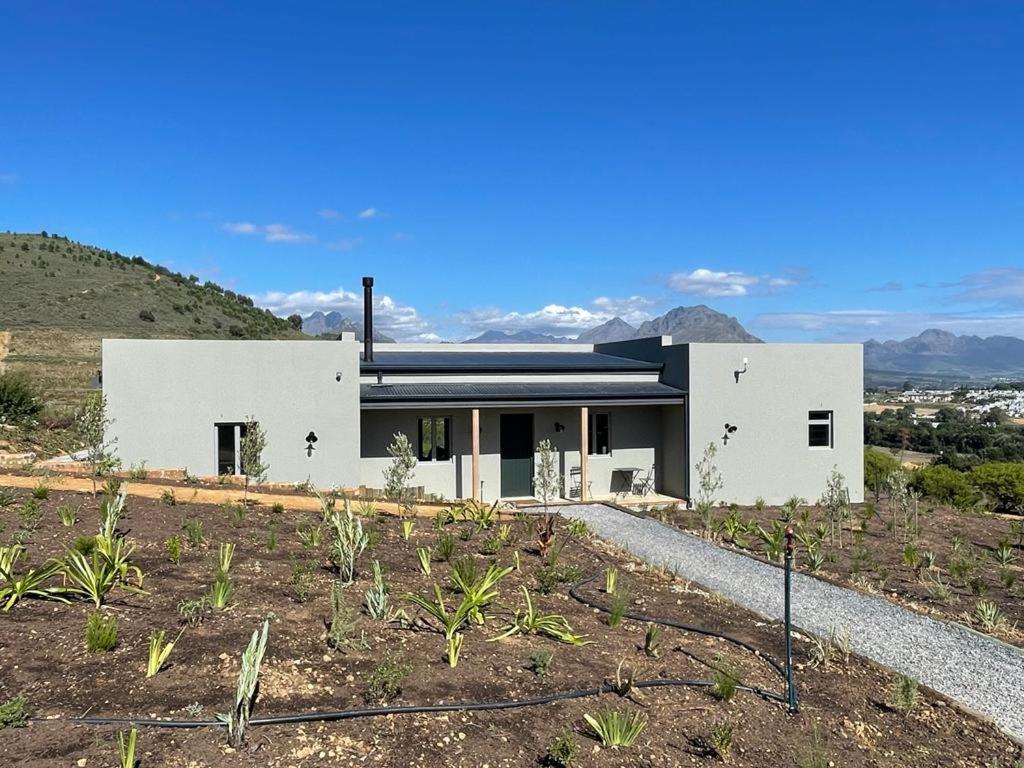 uma casa branca no topo de uma colina em Windon vineyard farmhouse em Stellenbosch