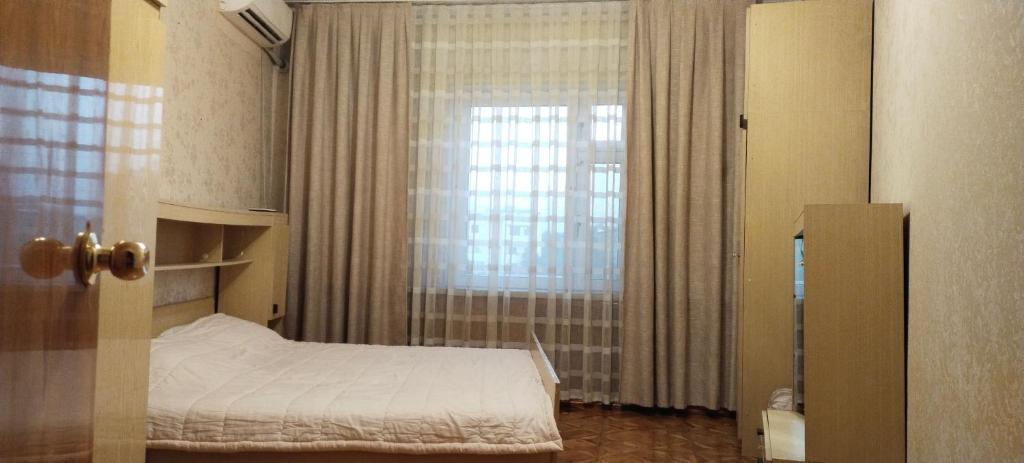 Un dormitorio pequeño con una cama y una ventana. en Yunusabad apartment 19, 1, en Magaldarkhan