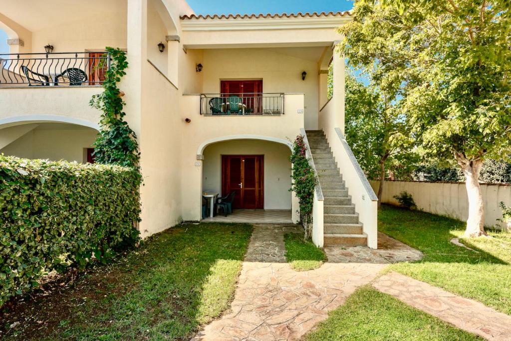 a house with a staircase leading to a red door at ISA-Apartments with air conditioning and external outdoor space in Budoni, at only 300 m from the beach in Budoni