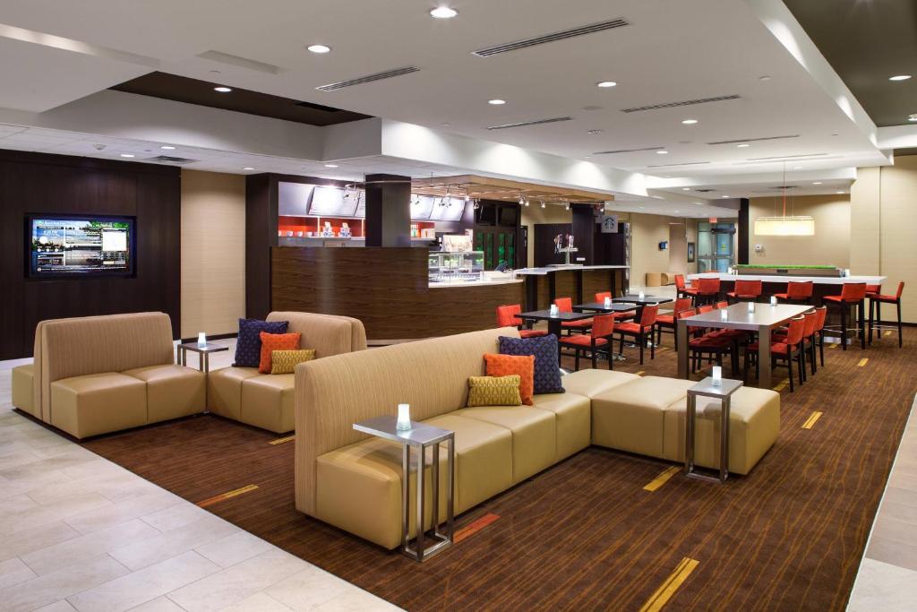 a lobby with couches and tables and a restaurant at Courtyard by Marriott London in London