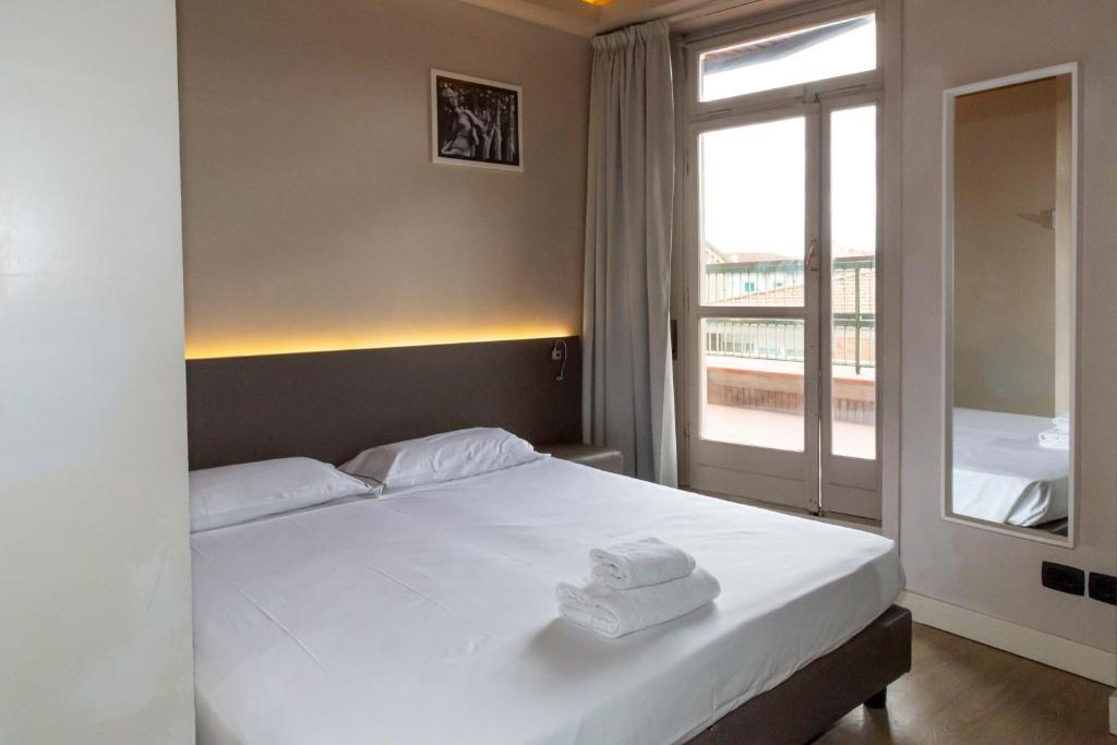 a bedroom with a bed with two towels on it at Plus Florence in Florence