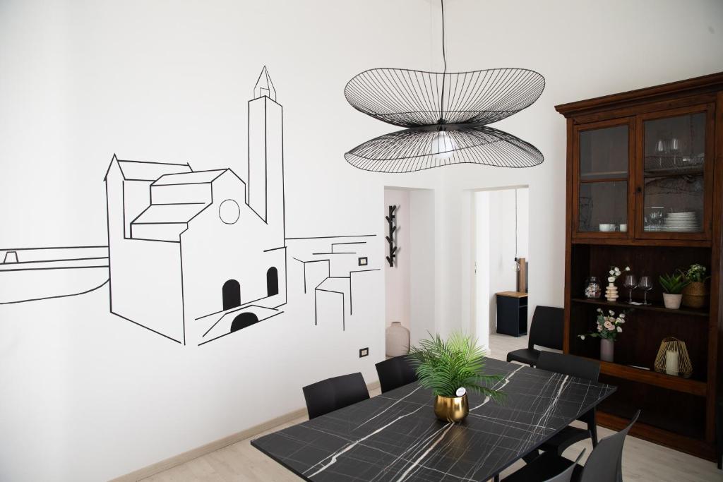 una sala da pranzo con tavolo e disegno sul muro di home72 a Trani