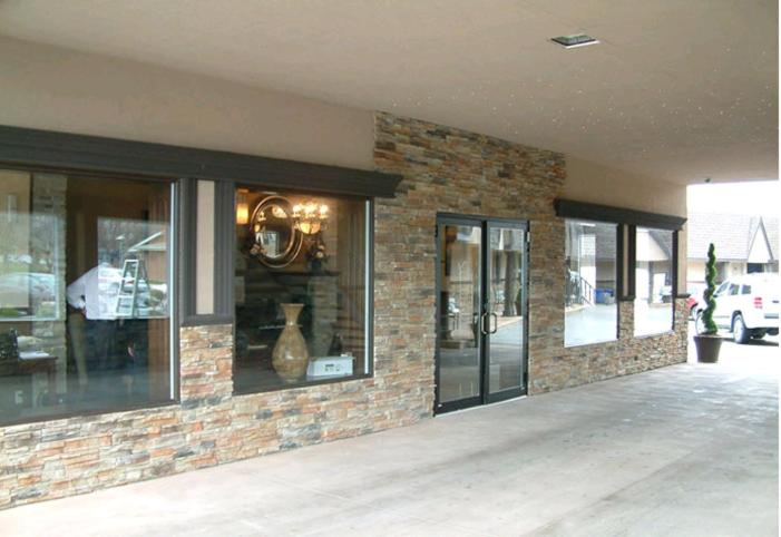 a store front with glass windows and a brick wall at Talbot Trail Inn & Suites in Leamington