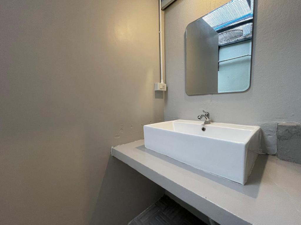 a bathroom with a white sink and a mirror at Comfort Zone Hostel @ Tha Pae in Chiang Mai