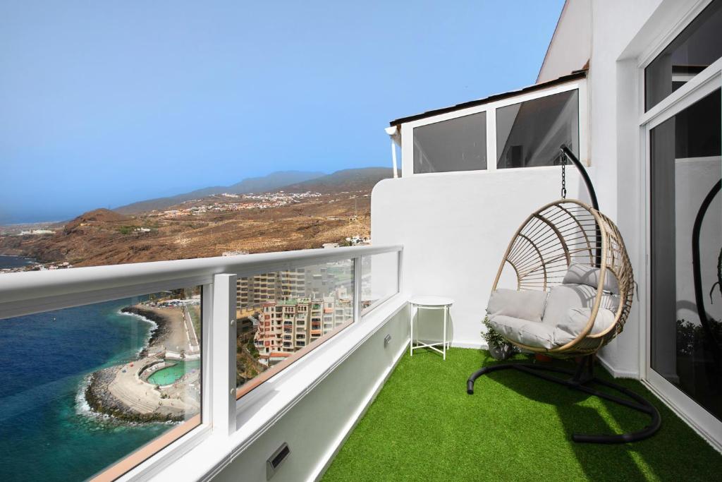balcón con silla de mimbre y vistas al océano en Beachfront Seaview Oasis, en Tabaiba