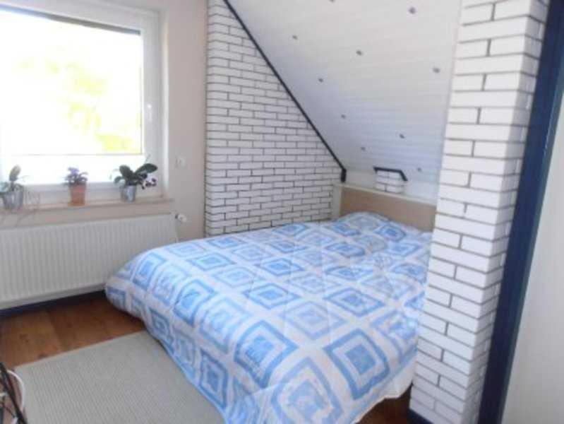 a bedroom with a bed and a brick wall at Privatzimmer Frank in Tarp