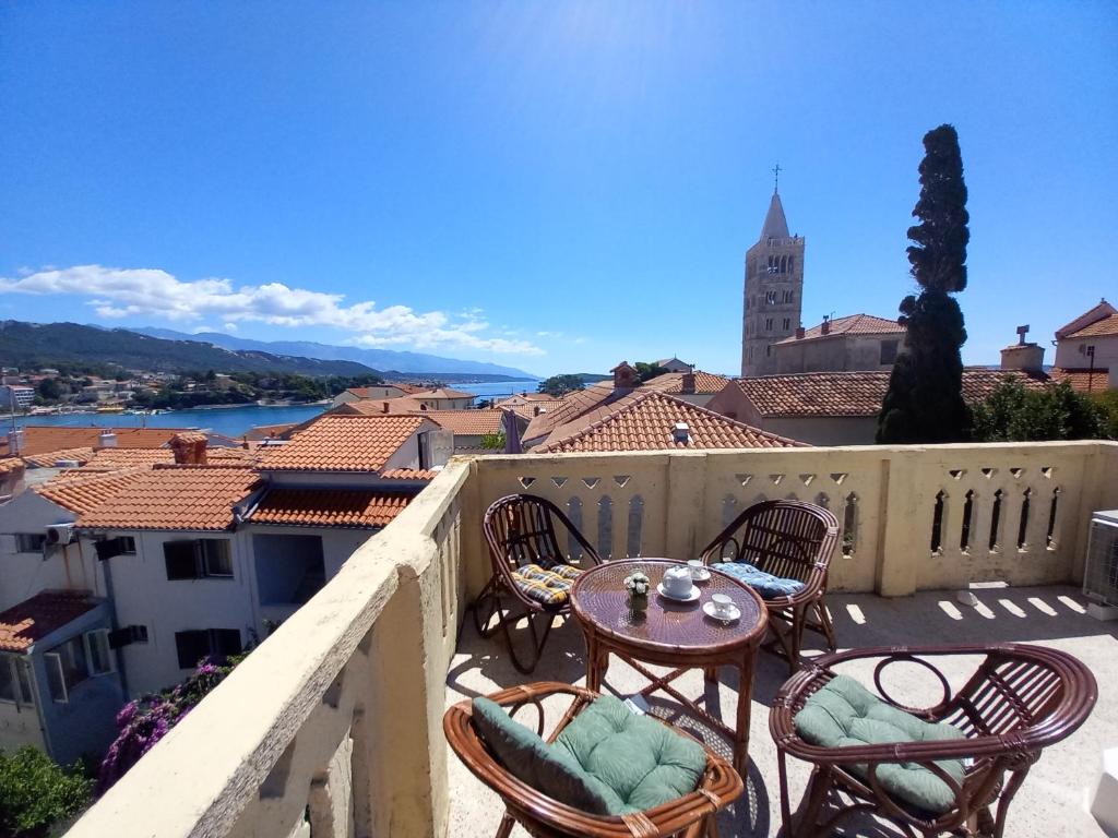 a balcony with tables and chairs and a view of a city at APT. OLD TOWN in Rab