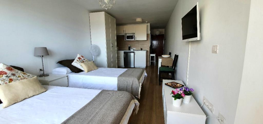 een kleine kamer met 2 bedden en een keuken bij Mirador del Atlántico - Aptos Tosca in Puerto de la Cruz
