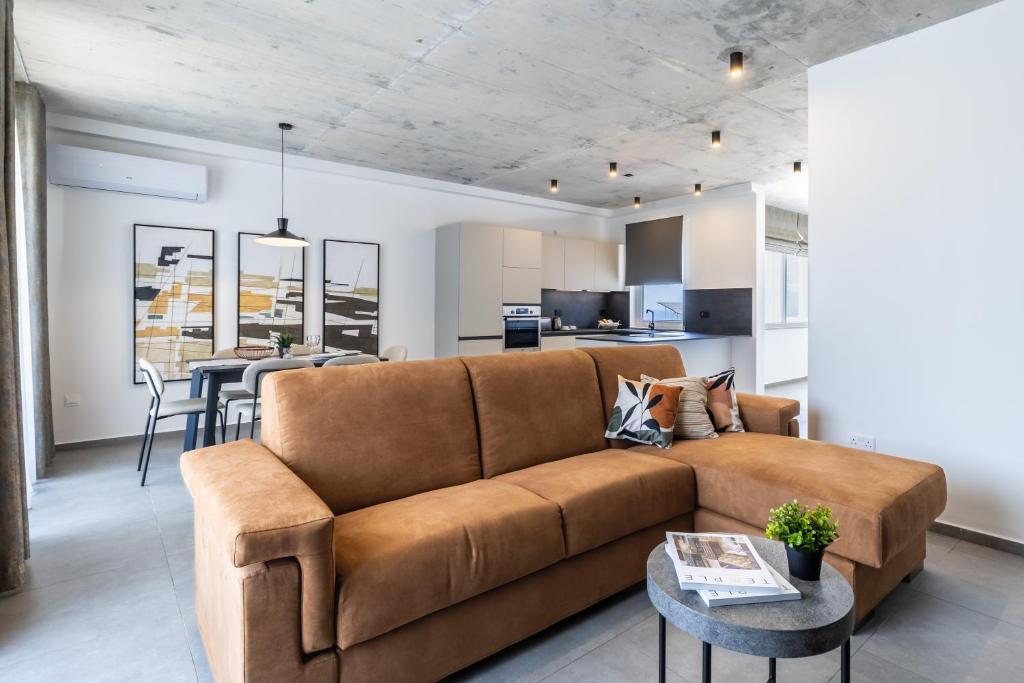 a living room with a brown couch and a kitchen at Seaside Luxury in Pembroke St Julians in Pembroke
