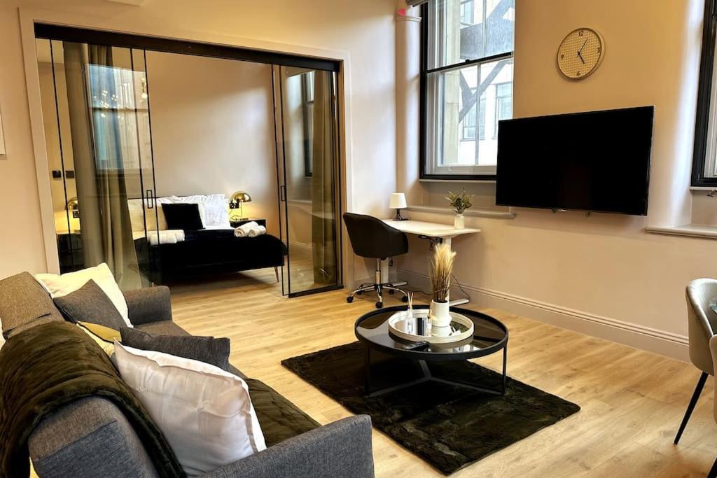 a living room with a couch and a tv at Stunning 2BR Apt in Central Manc in Manchester