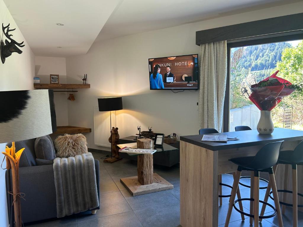 a living room with a couch and a tv on the wall at Les Trois Chaufatons - Chalets Boutiques in Montriond