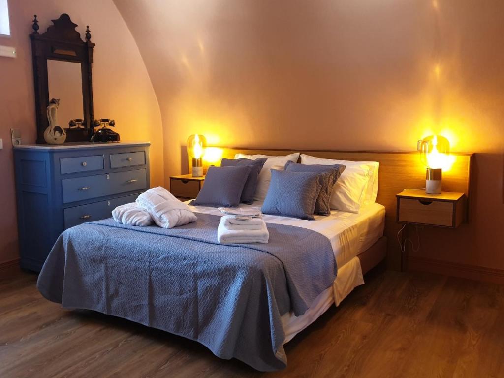 1 dormitorio con 1 cama con toallas en PhiloXenia Traditional Apartments, en Chios