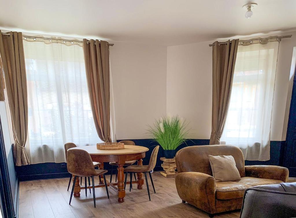 een woonkamer met een tafel en stoelen bij L’Estaminet 