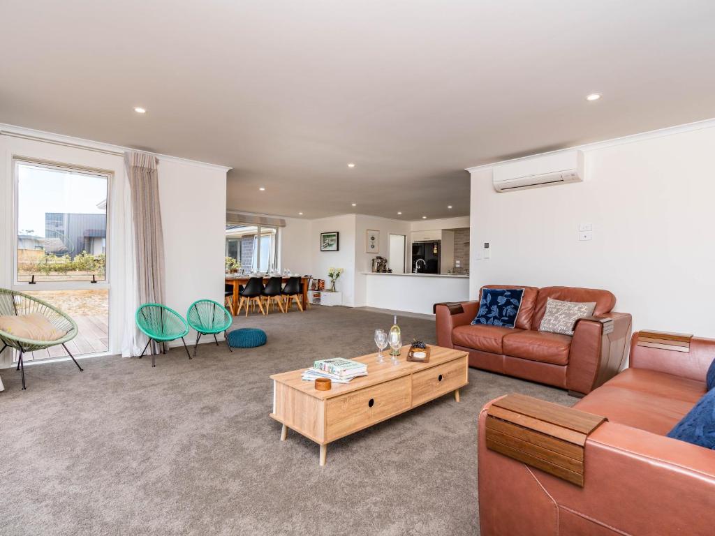 a living room with a couch and a table at Bach near the Beach - Mangawhai Heads Holiday Home in Mangawhai