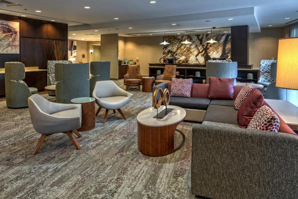 a lobby with couches and chairs in a hotel at Courtyard Newport News Airport in Newport News